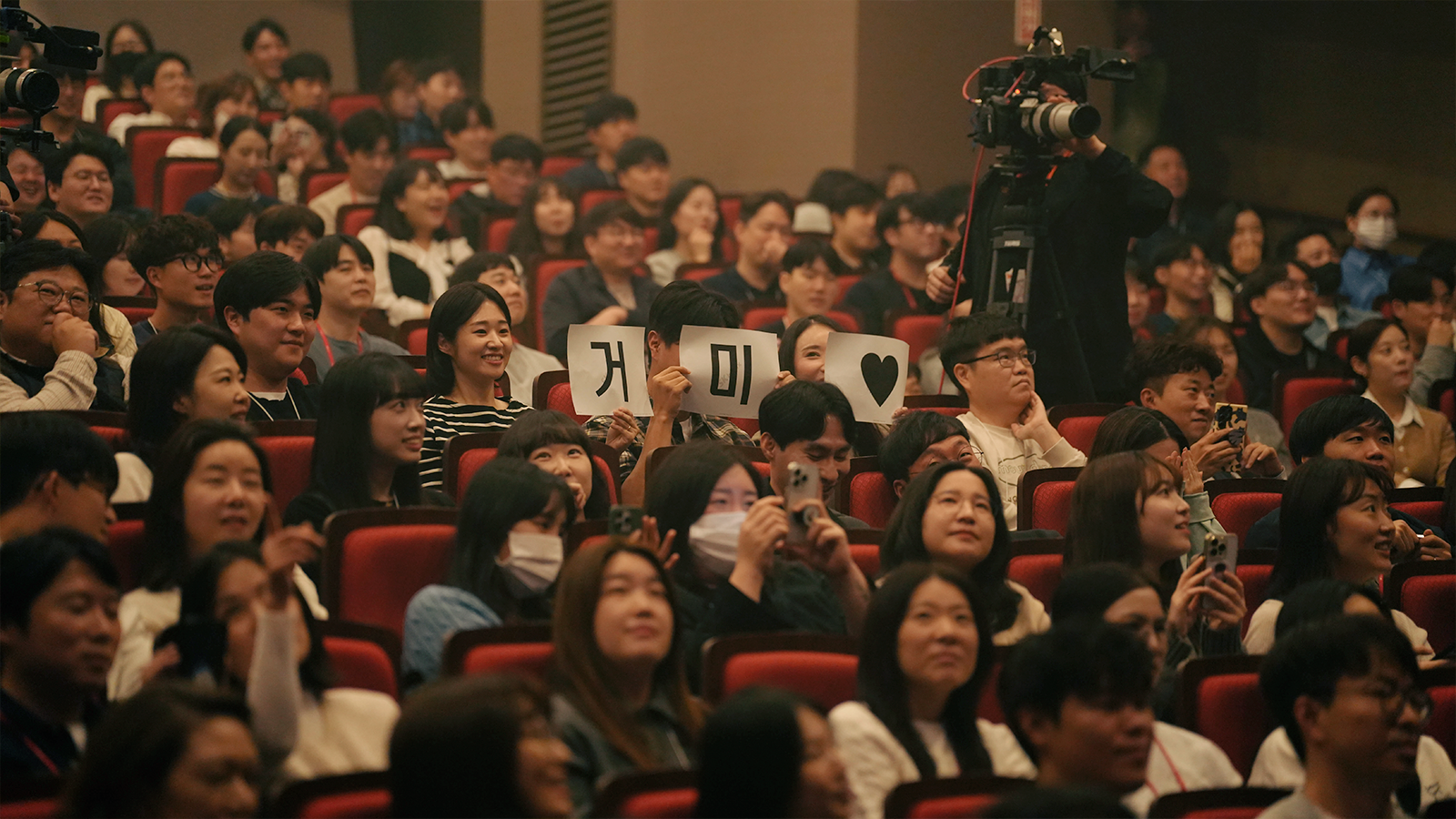 가수 거미가 무대와 객석을 오가며 열창하는 가운데, SK하이닉스 구성원들이 그 모습을 보며 공연을 즐기고 있다.